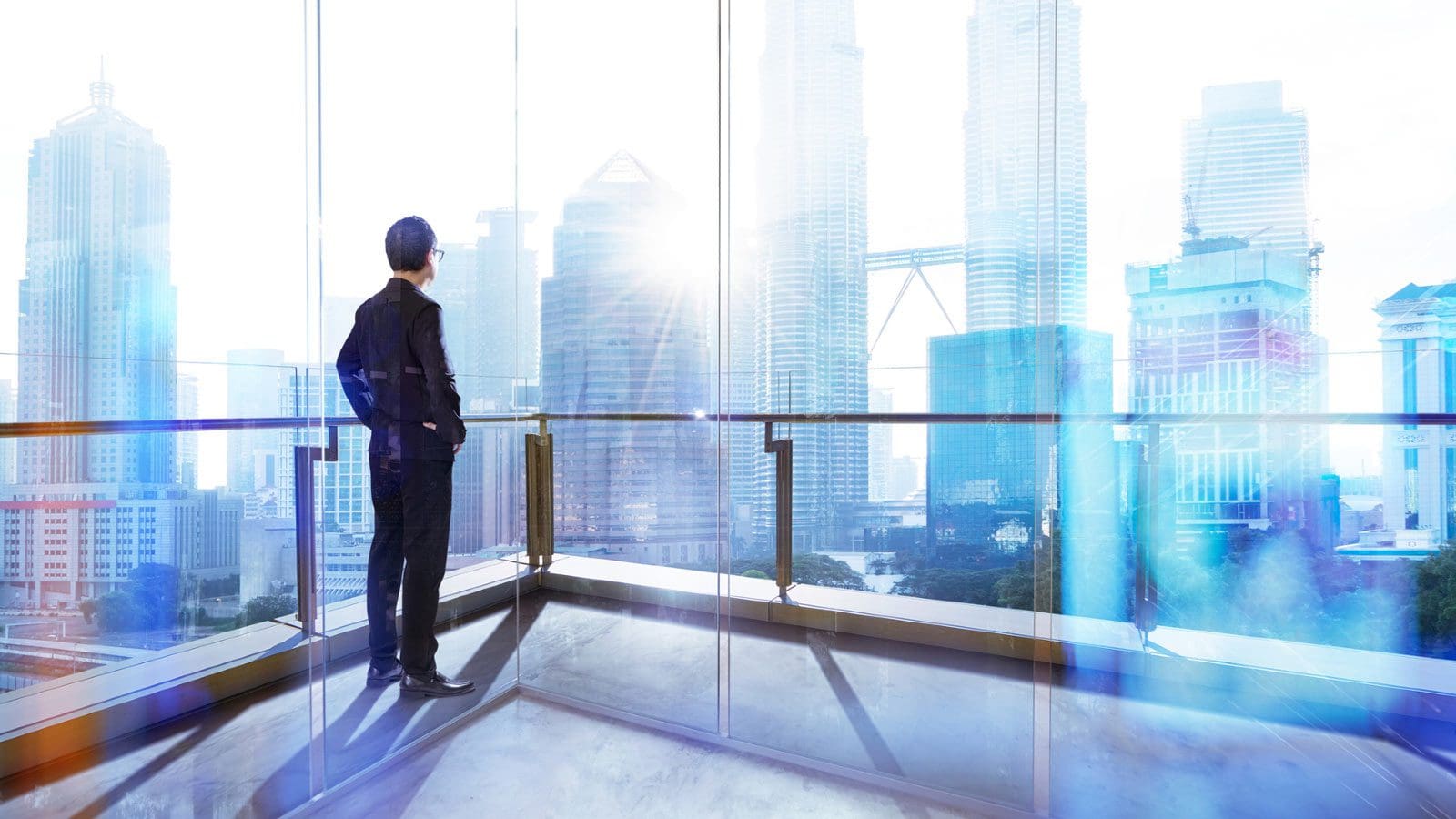 Man optimistically looking out corporate window