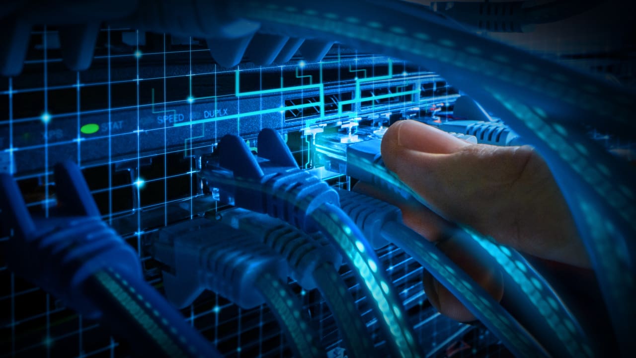Person plugging in ethernet cables into a device.