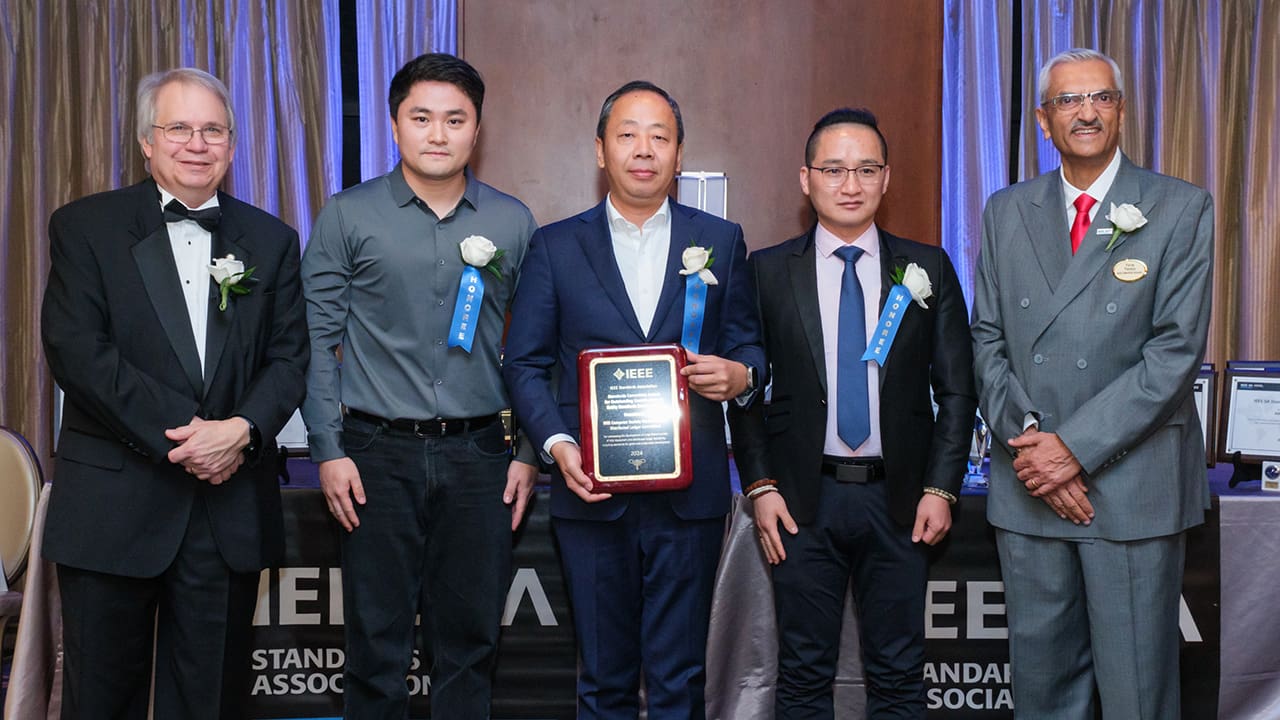 IEEE SA President Jim Matthews and Yatin Trivedi posing for a photo with IEEE SA Awards honorees.